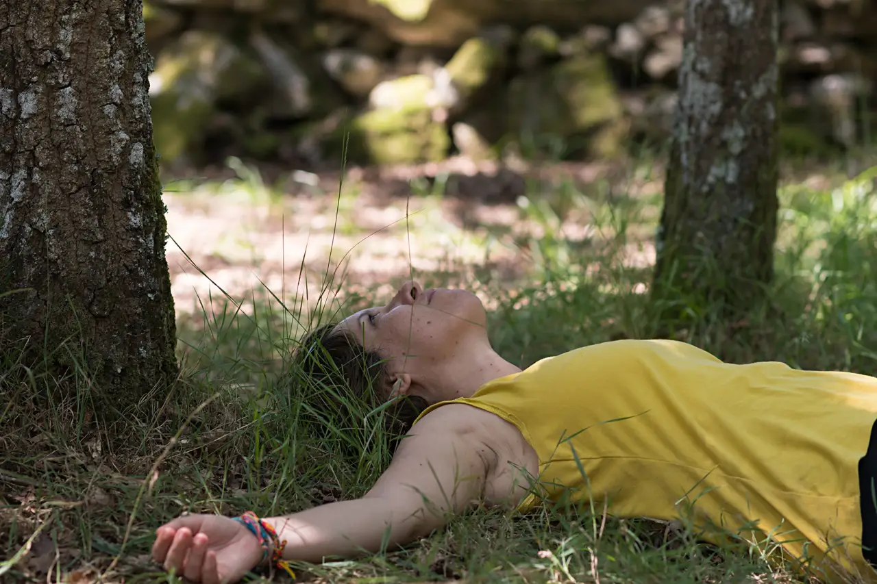 Aprender a meditar: una puerta hacia el silencio interior persona sentada en postura de meditación en espacio natural con los ojos cerrados y expresión serena