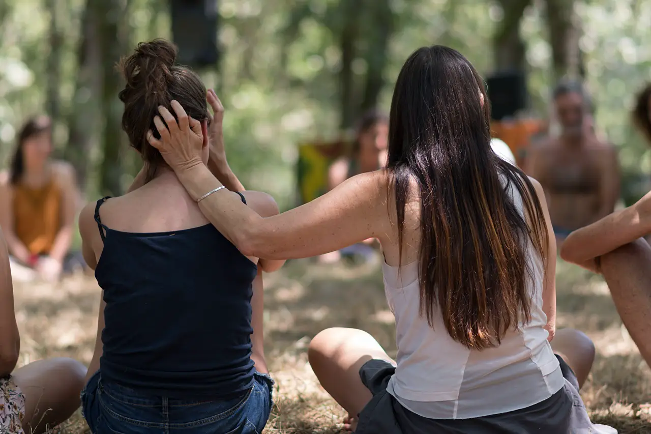 Sanar las heridas emocionales: el camino se hace acompañado dos personas en un entorno natural sentadas juntas en actitud de conversación tranquila y acompañamiento